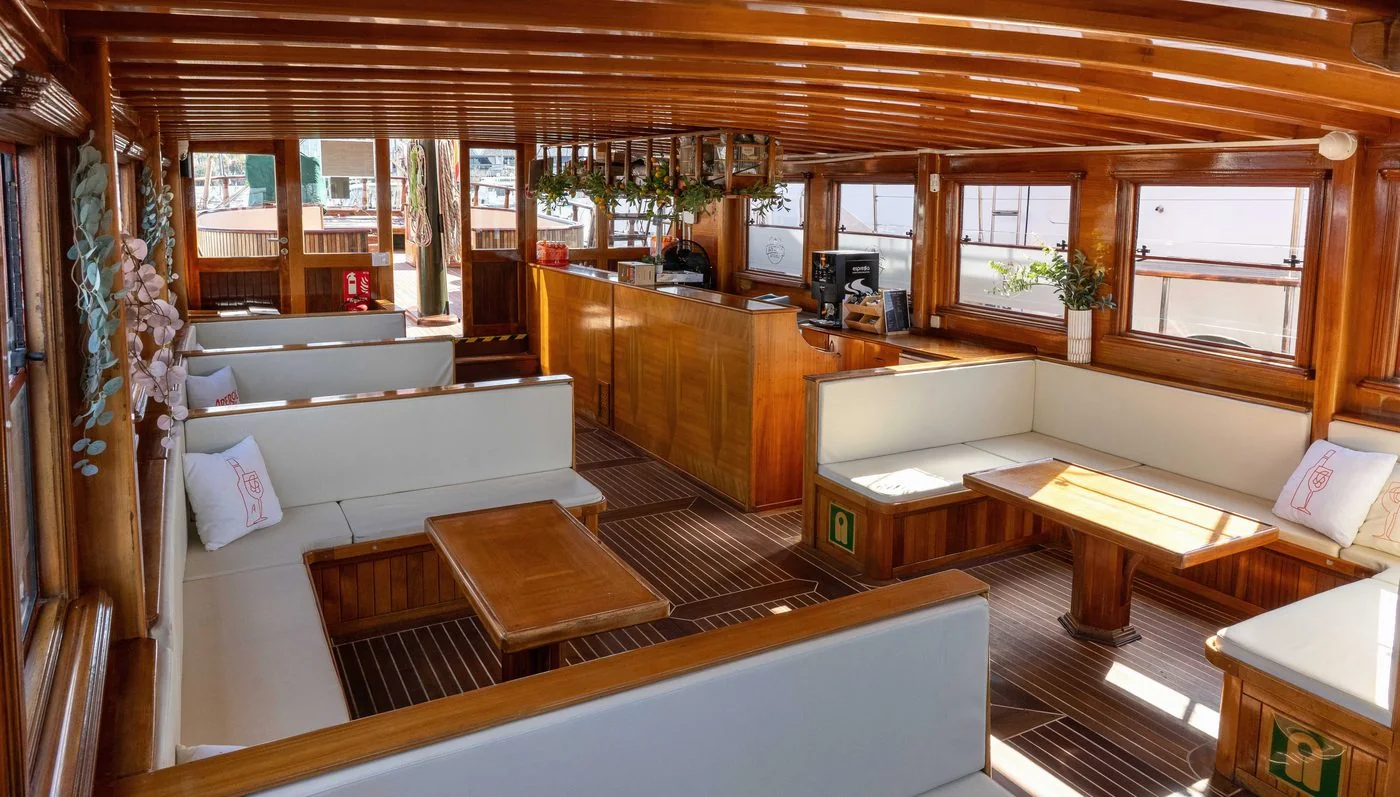 The warm wood interior of the boat, cream banquettes and soft afternoon light